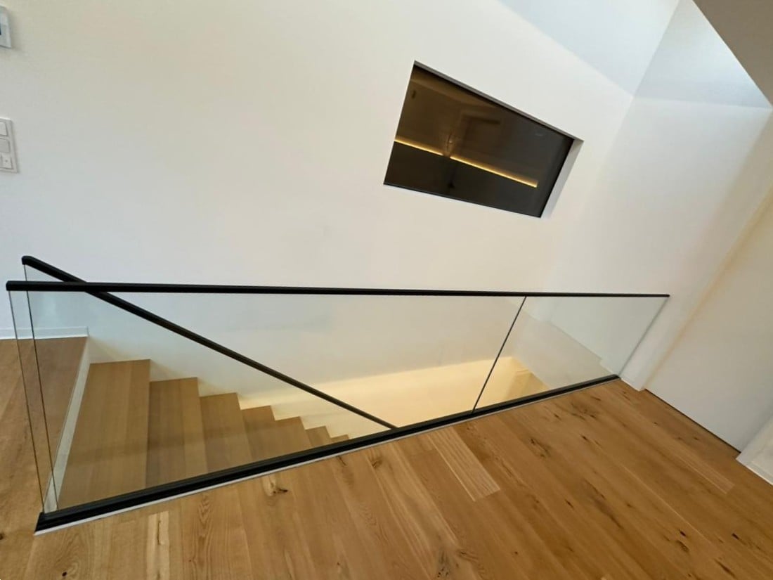 Kragarmtreppe in Massiveiche in Saarbrücken, schwebende Stufen an Stahlbetonwand